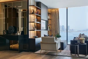 One at Palm Jumeirah Dorchester Collection by Omniyat living area with custom shelving and waterfront view in Dubai - Presented by Tohid Fetrat