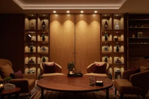 One at Palm Jumeirah Dorchester Collection by Omniyat lounge with wood shelving decorative objects and warm lighting in Dubai - Presented by Tohid Fetrat