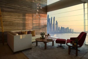 One at Palm Jumeirah Dorchester Collection by Omniyat lounge with floor to ceiling windows and waterfront skyline view in Dubai - Presented by Tohid Fetrat