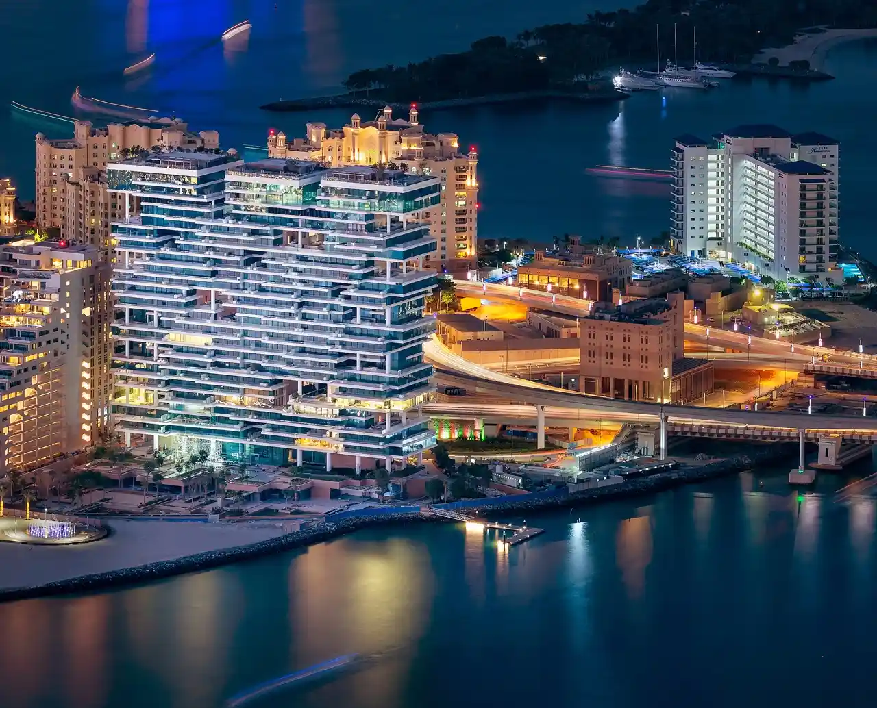 One at Palm Jumeirah Dorchester Collection by Omniyat night aerial view with illuminated waterfront and surrounding skyline in Dubai - Presented by Tohid Fetrat