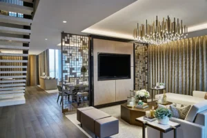 One at Palm Jumeirah Dorchester Collection by Omniyat open plan living area with TV wall chandelier and staircase in Dubai - Presented by Tohid Fetrat