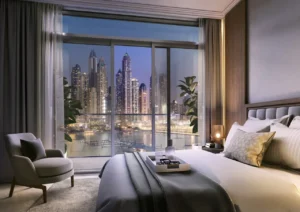 Palace Beach Residence at Emaar Beachfront by Emaar bedroom with floor to ceiling windows and marina skyline night view in Dubai - Presented by Tohid Fetrat