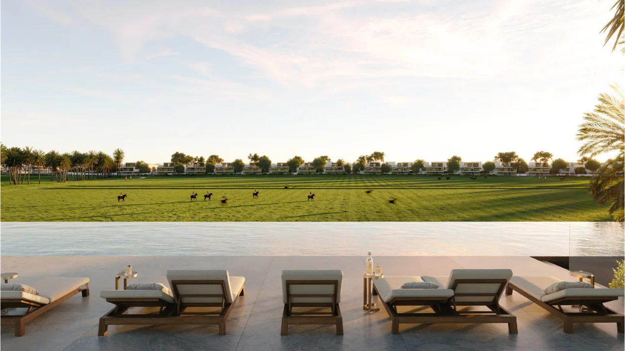 Selvara at Grand Polo Club & Resort by Emaar infinity pool terrace with sun loungers overlooking polo field and luxury villas in Dubai - Presented by Tohid Fetrat