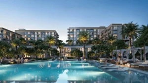 Sera 1 at Rashid Yachts & Marina by Emaar evening pool view with cabanas palm trees illuminated residential buildings and leisure areas in Dubai - Presented by Tohid Fetrat