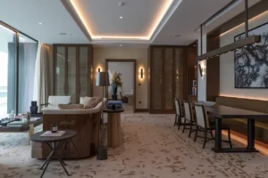 The Lana Residences Dorchester Collection by Omniyat 2 bedroom living and dining area with modern furnishings and warm lighting in Dubai - Presented by Tohid Fetrat