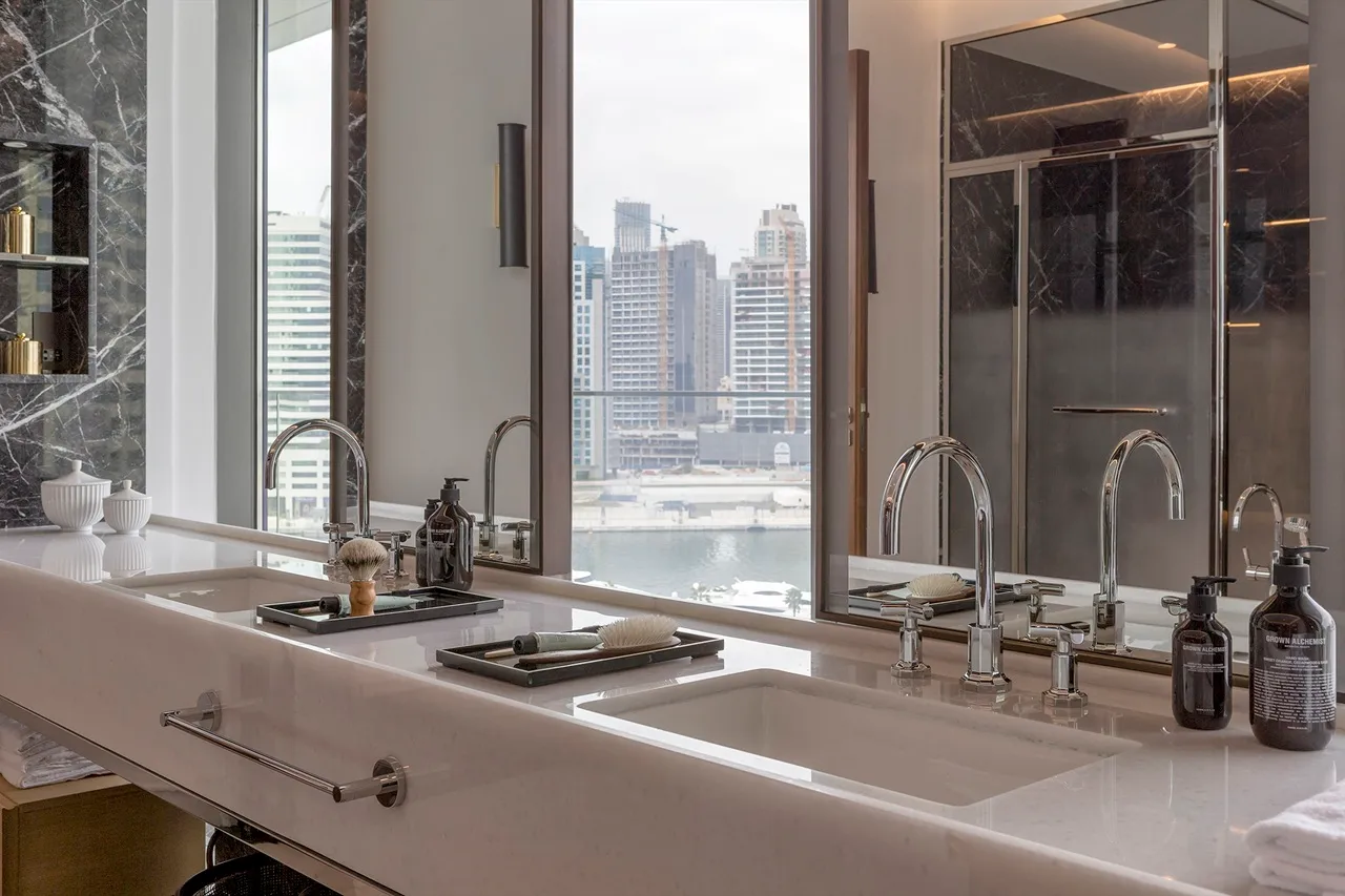 The Lana Residences Dorchester Collection by Omniyat 4 bedroom bathroom with marble double vanity skyline view and premium fittings in Dubai - Presented by Tohid Fetrat