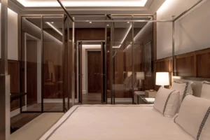 The Lana Residences Dorchester Collection by Omniyat 4 bedroom bedroom with glass wardrobe panels wood finishes and ambient lighting in Dubai - Presented by Tohid Fetrat