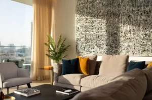 The Lana Residences Dorchester Collection by Omniyat 4 bedroom duplex living area with textured wall art and natural light in Dubai - Presented by Tohid Fetrat