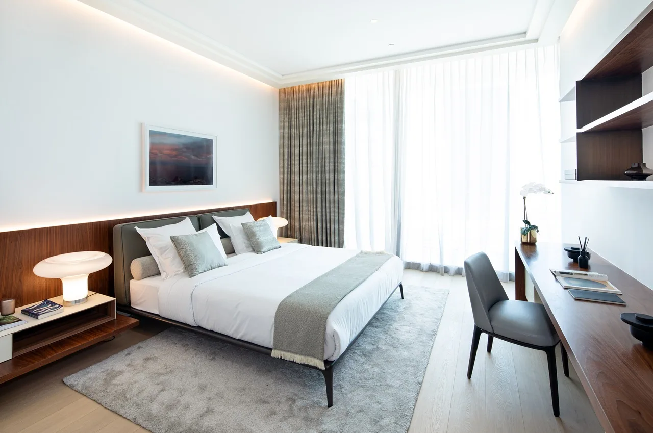 The Lana Residences Dorchester Collection by Omniyat 4 bedroom duplex master bedroom with soft lighting neutral tones and floor to ceiling curtains in Dubai - Presented by Tohid Fetrat