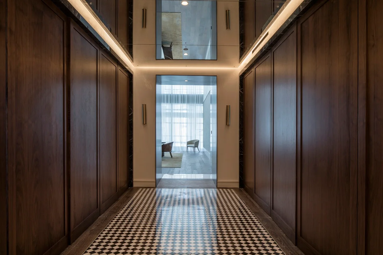 The Lana Residences Dorchester Collection by Omniyat 4 bedroom hallway with wood paneling patterned flooring and soft lighting in Dubai - Presented by Tohid Fetrat