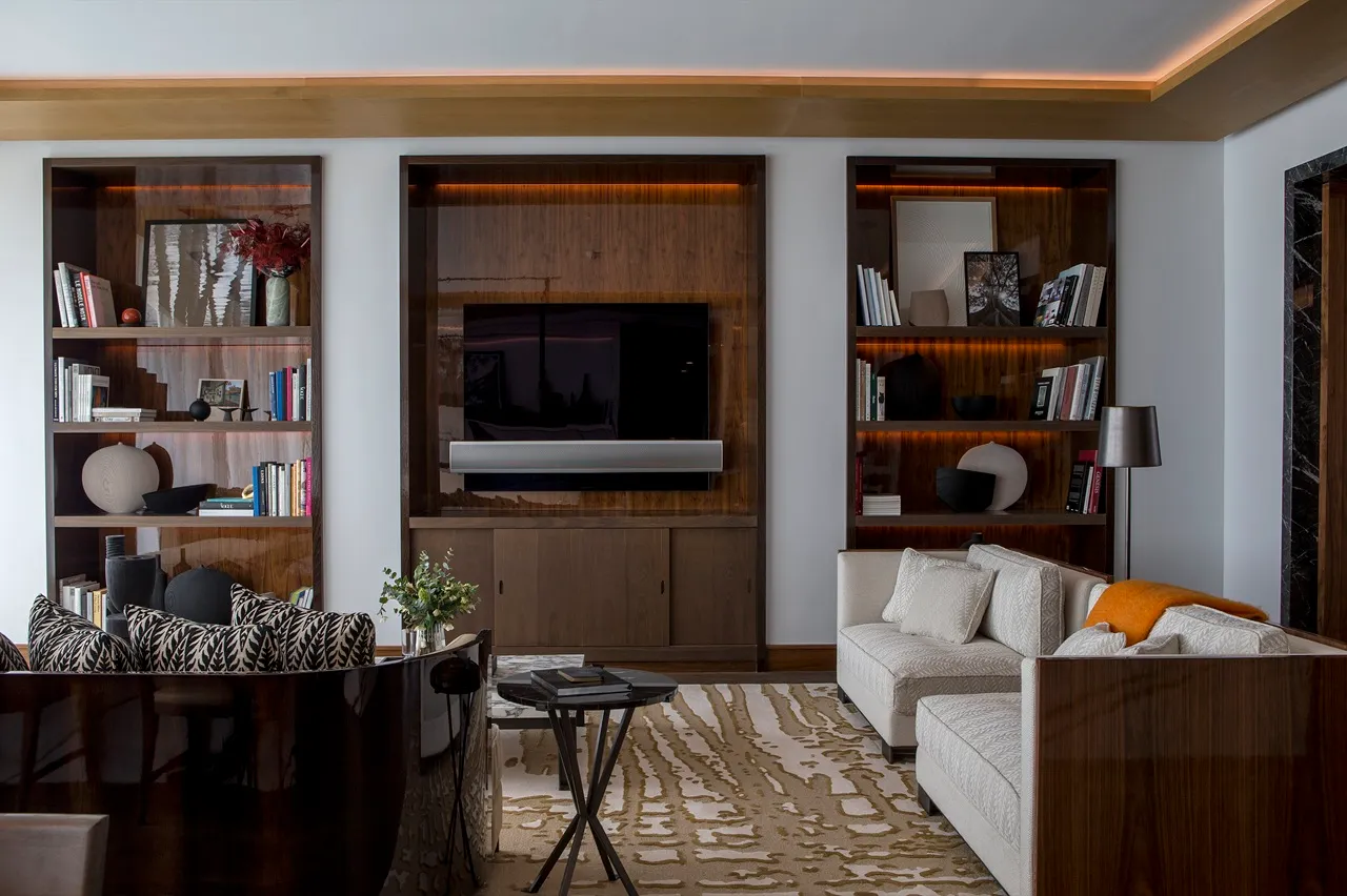 The Lana Residences Dorchester Collection by Omniyat 4 bedroom living room with media wall built in shelving and warm lighting in Dubai - Presented by Tohid Fetrat