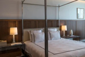 The Lana Residences Dorchester Collection by Omniyat 4 bedroom master bedroom with canopy bed wood paneling and soft lighting in Dubai - Presented by Tohid Fetrat