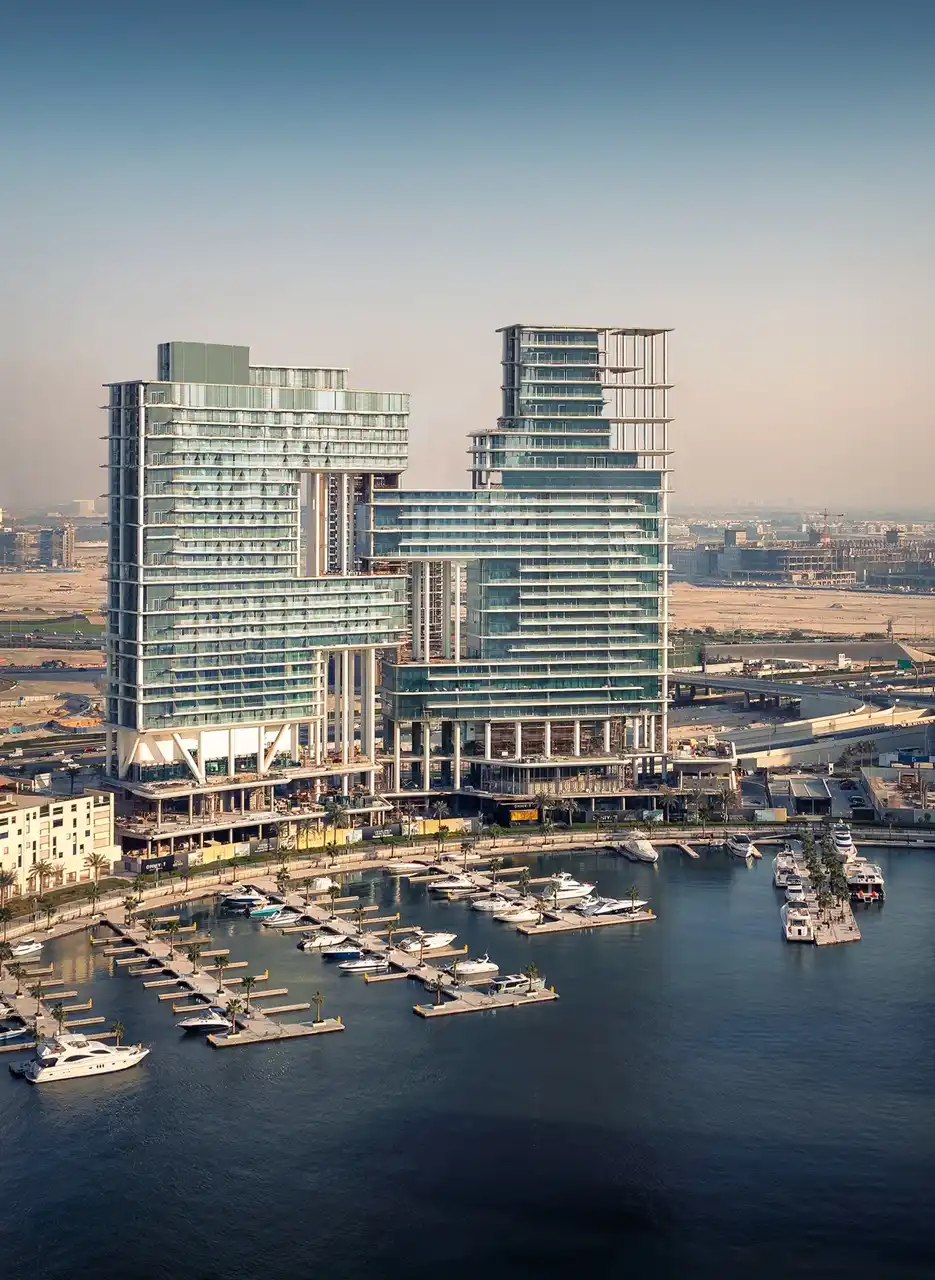 The Lana Residences Dorchester Collection by Omniyat aerial view of waterfront towers and marina with yachts in Dubai - Presented by Tohid Fetrat
