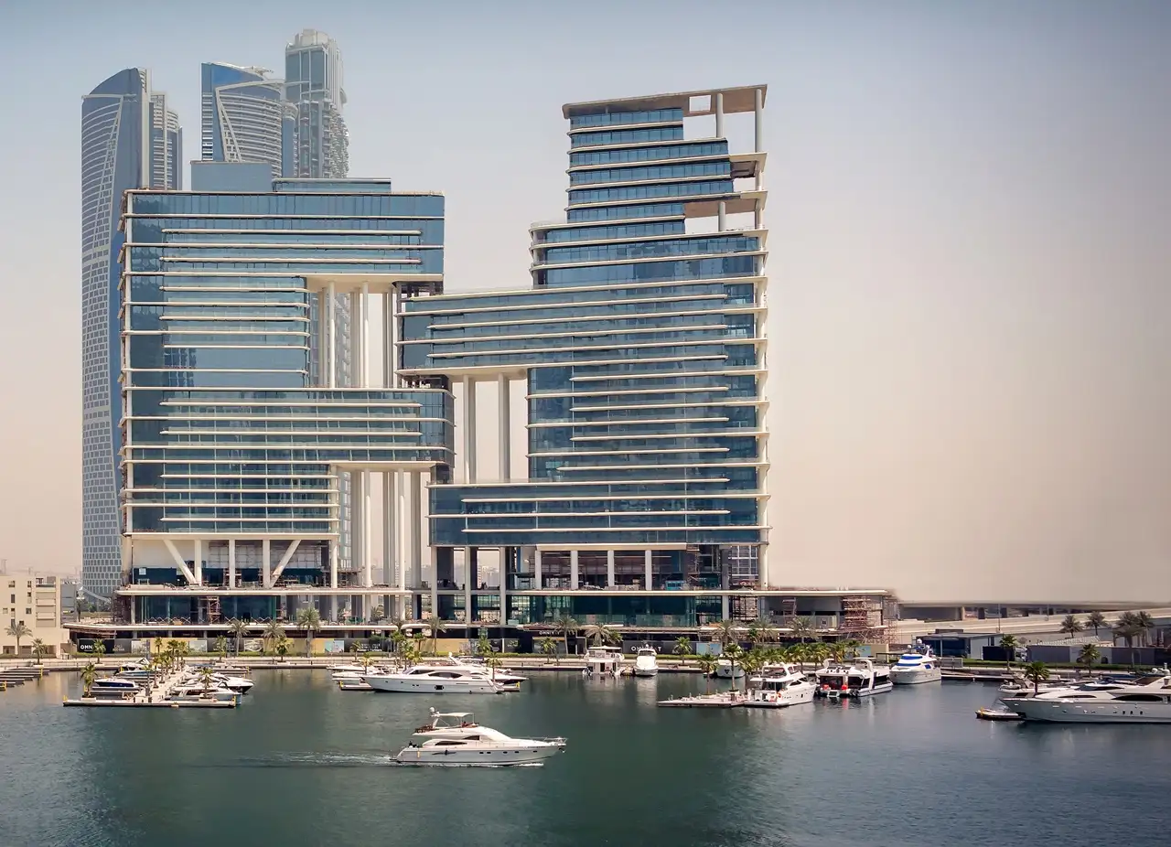 The Lana Residences Dorchester Collection by Omniyat marina waterfront view with yachts and modern glass towers in Dubai - Presented by Tohid Fetrat