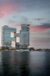 The Lana Residences Dorchester Collection by Omniyat waterfront exterior with modern glass architecture and marina views at sunset in Dubai - Presented by Tohid Fetrat