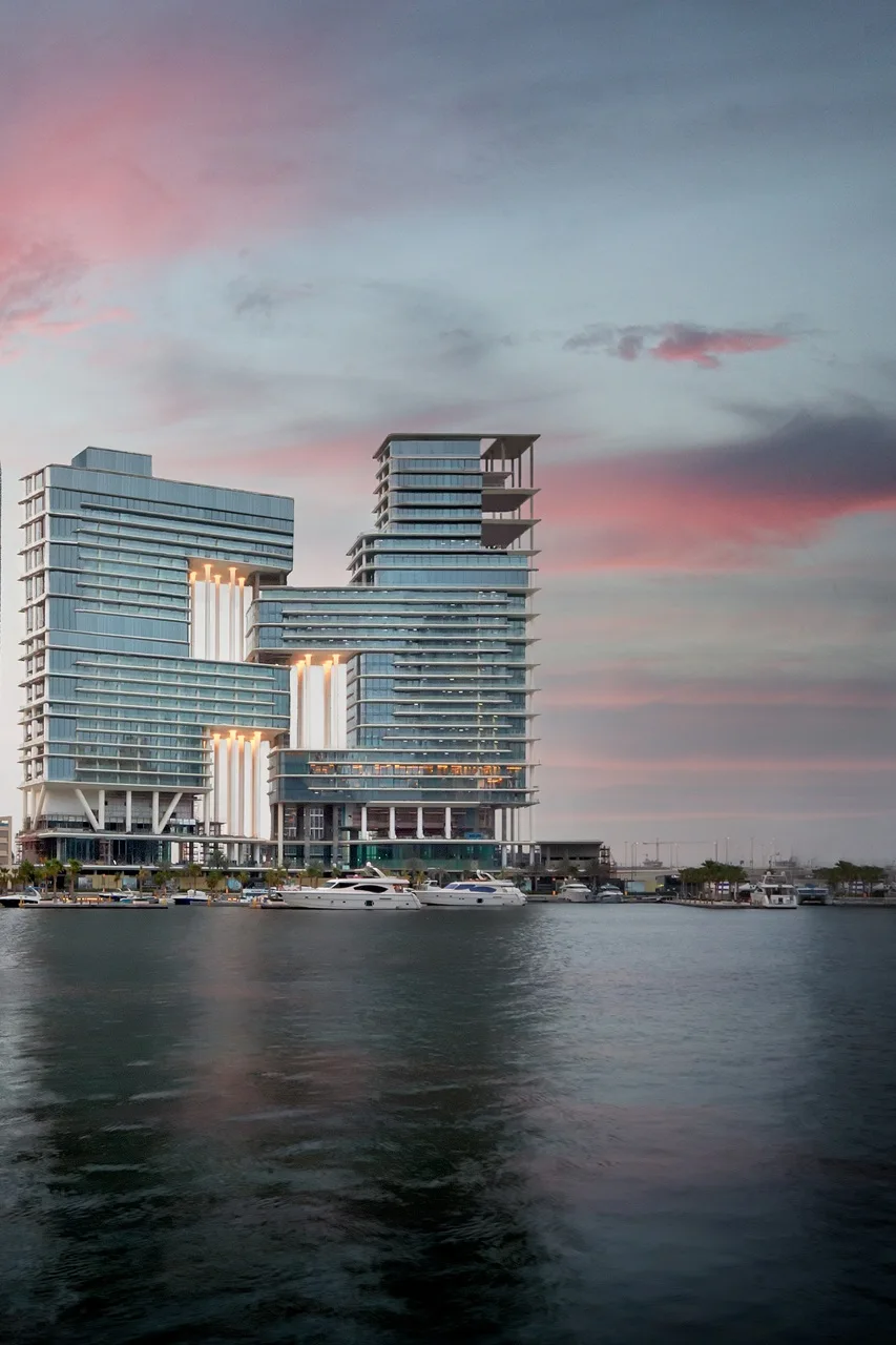 The Lana Residences Dorchester Collection by Omniyat waterfront exterior with modern glass architecture and marina views at sunset in Dubai - Presented by Tohid Fetrat