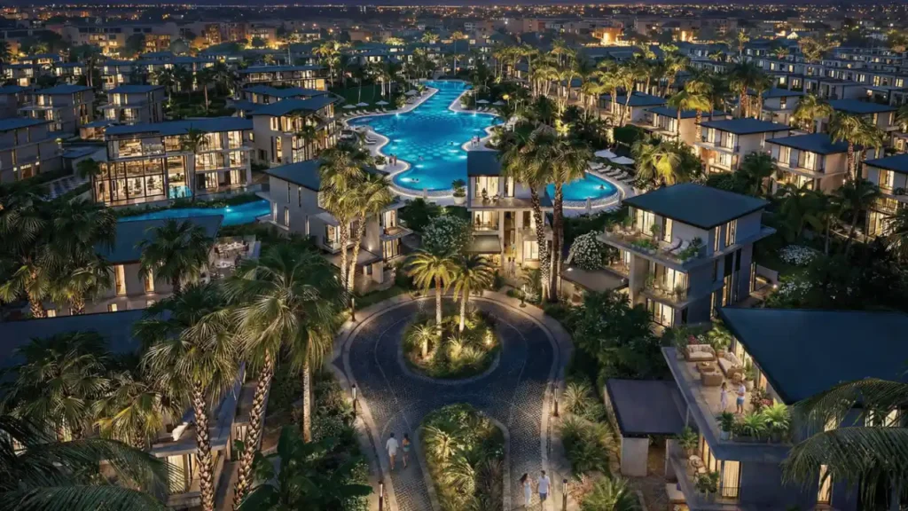 Tilal Binghatti community featuring luxury villas surrounding a lagoon style pool with landscaped pathways and palm trees at night in Dubai Presented by Tohid Fetrat