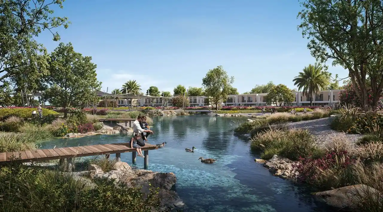 Vindera at The Valley by Emaar lagoon waterfront with wooden deck seating landscaped greenery and water features in Dubai - Presented by Tohid Fetrat