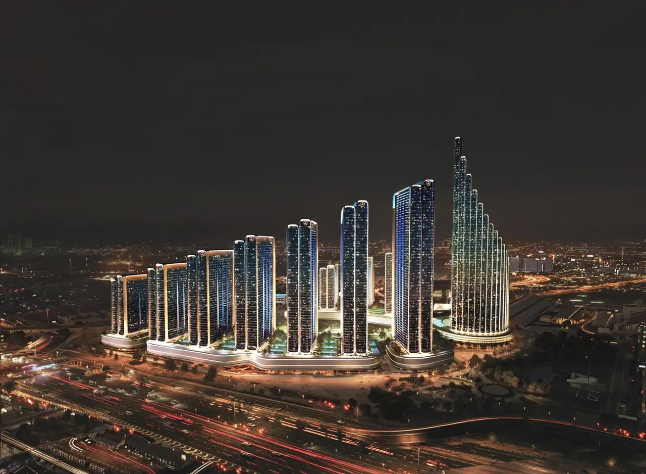 Binghatti Properties for Sale in Dubai featuring modern high rise towers with illuminated facades and large scale development at night Presented by Tohid Fetrat