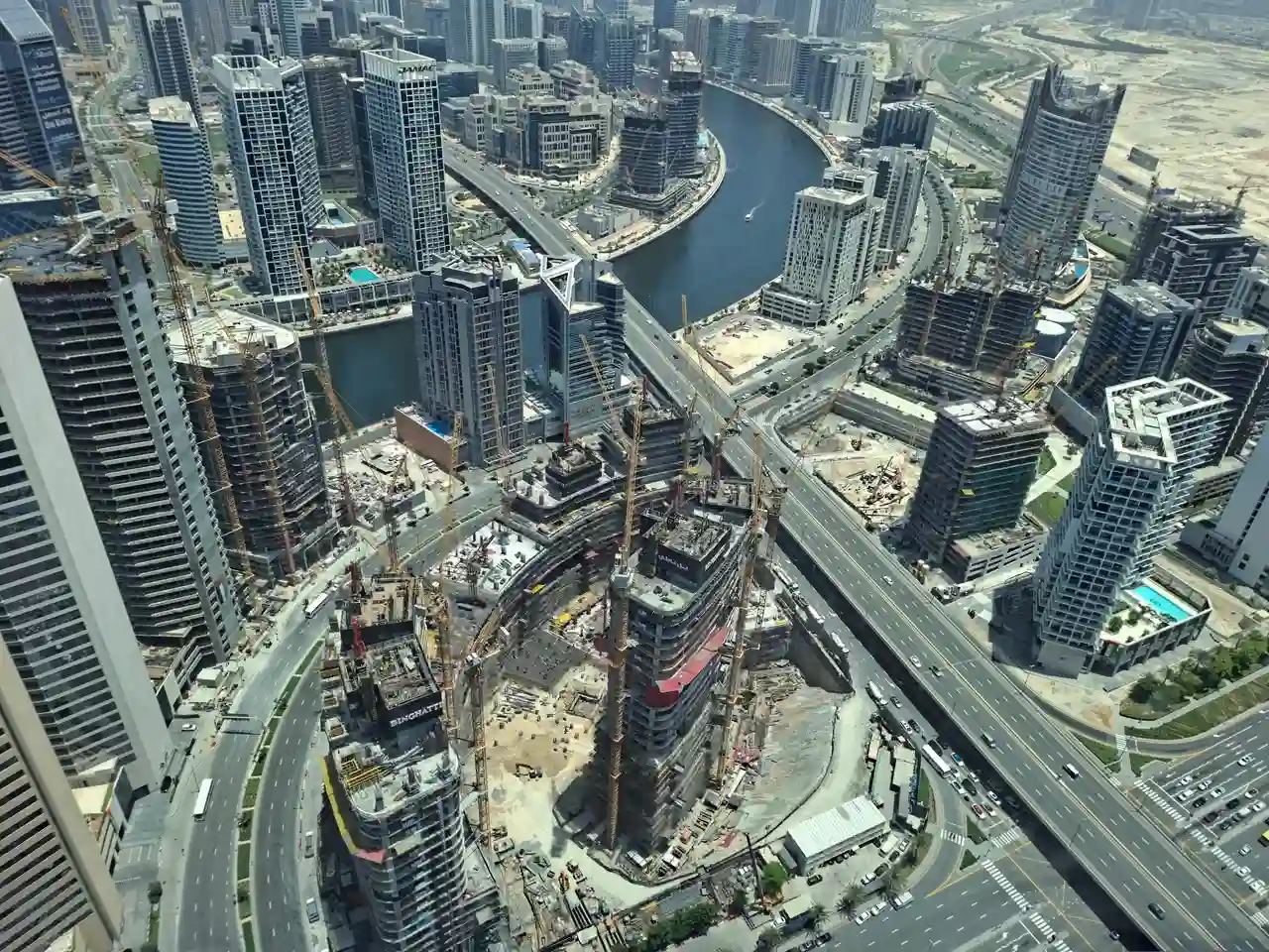 Business Bay construction towers and Dubai Canal skyline during active development in Dubai Presented by Tohid Fetrat