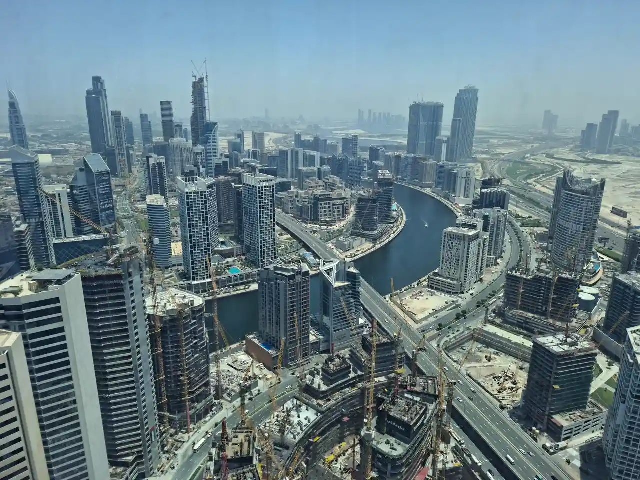 Aerial view of active high-rise construction, cranes, and ongoing urban development progress in Dubai Presented by Tohid Fetrat