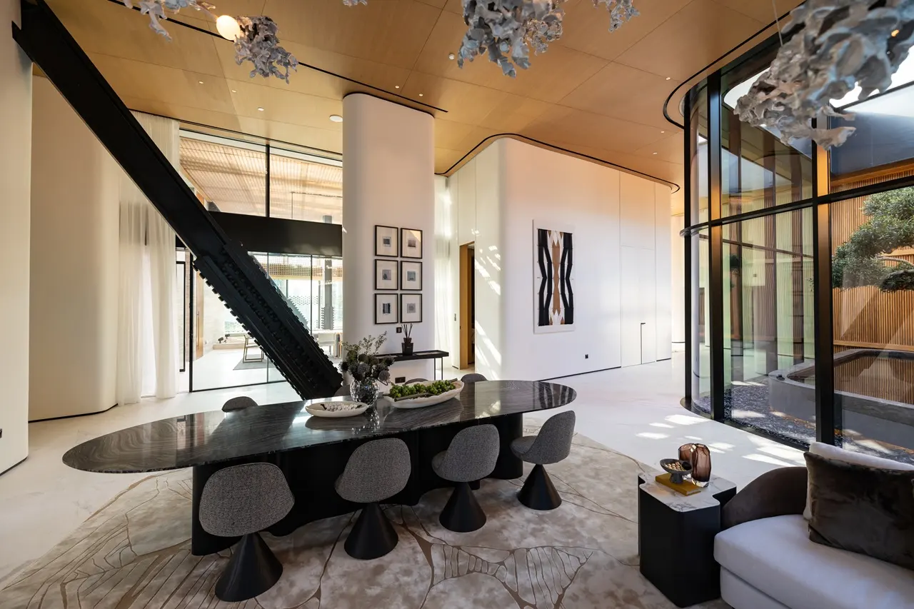 The Opus Penthouse by OMNIYAT designer dining area with sculptural staircase, double height ceilings, and luxury contemporary interiors in Dubai - Presented by Tohid Fetrat