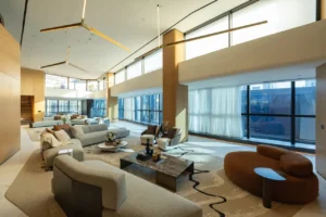 The Opus Penthouse by OMNIYAT double height lounge space with floor to ceiling windows, designer seating, and luxury contemporary interiors in Dubai - Presented by Tohid Fetrat