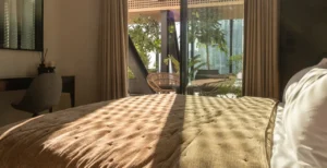 The Opus Penthouse by OMNIYAT guest bedroom with warm natural lighting, terrace views, and contemporary luxury interiors in Dubai - Presented by Tohid Fetrat