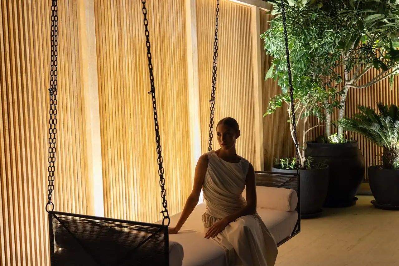 The Opus Penthouse by OMNIYAT luxury lounge seating area with ambient lighting, natural greenery, and contemporary interior design in Dubai - Presented by Tohid Fetrat