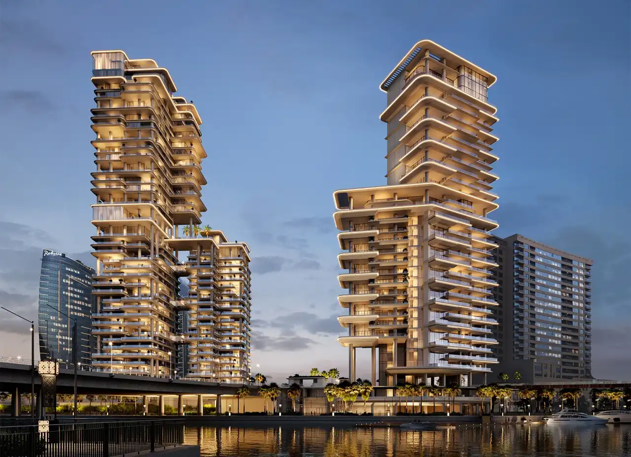 VELA by OMNIYAT construction update May 2023 showing illuminated waterfront towers in Business Bay Dubai Presented by Tohid Fetrat