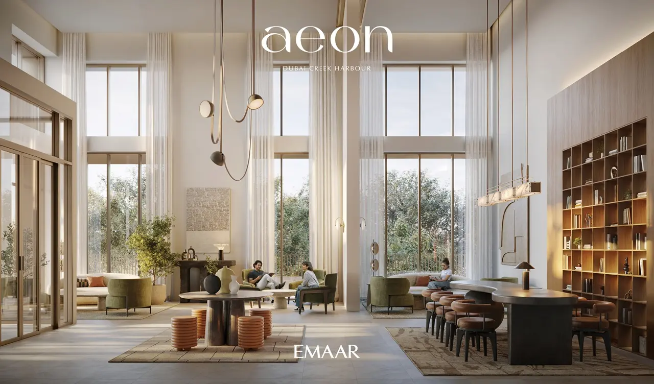 AEON at Dubai Creek Harbour by Emaar Properties double height lounge interior with tall windows, elegant seating, library wall and refined neutral finishes in Dubai Presented by Tohid Fetrat