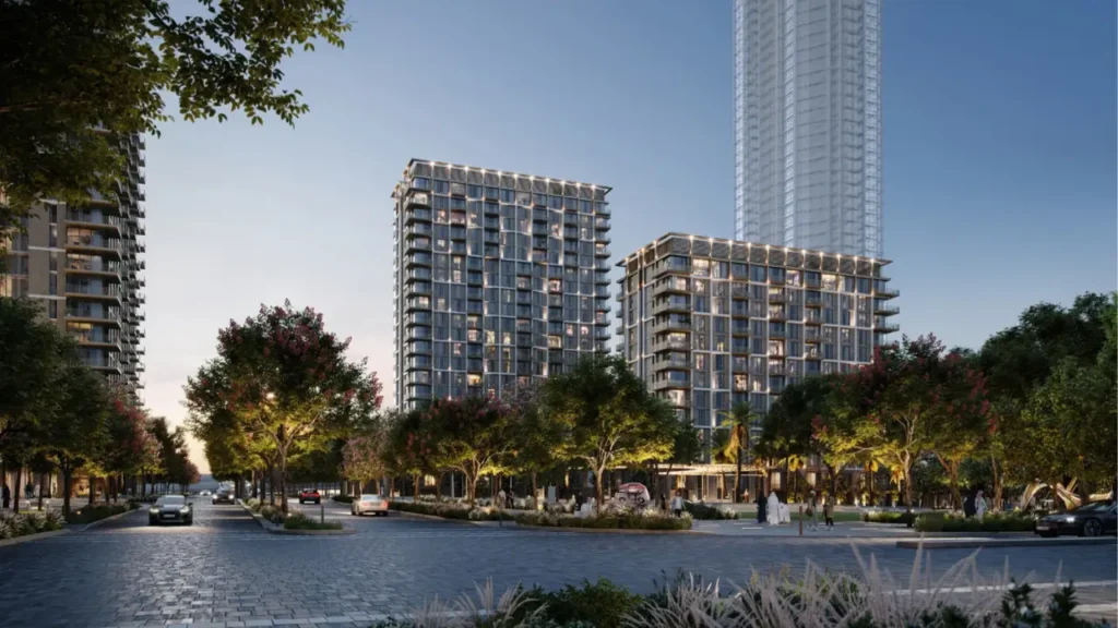 AEON at Dubai Creek Harbour by Emaar Properties residential towers with tree lined boulevard, illuminated facades, landscaped greenery and evening urban setting in Dubai Presented by Tohid Fetrat