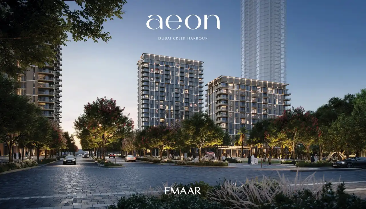 AEON at Dubai Creek Harbour by Emaar Properties residential towers with tree lined boulevard, illuminated facades, landscaped greenery and evening city setting in Dubai Presented by Tohid Fetrat