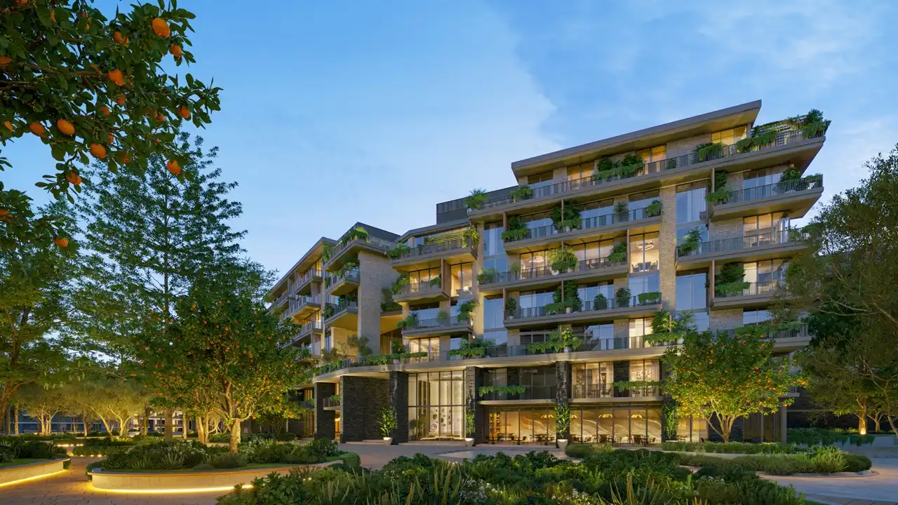 Arancia at The Yards by Beyond Developments residential facade surrounded by landscaped gardens and citrus trees at dusk in Dubai - Presented by Tohid Fetrat