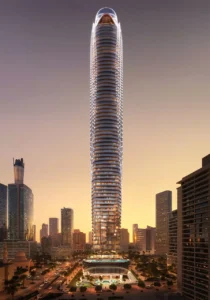 Binghatti Skyblade by Binghatti iconic residential tower with illuminated facade rising above the Dubai skyline at sunset in Dubai - Presented by Tohid Fetrat