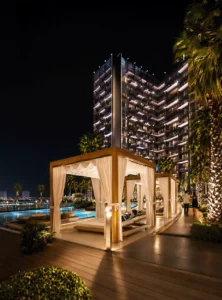 Binghatti Wraith at Al Jaddaf by Binghatti luxury poolside cabanas with resort style amenities and illuminated waterfront setting in Dubai - Presented by Tohid Fetrat