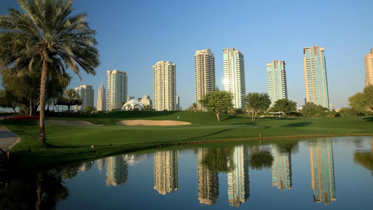 Dubai Media City properties for sale overlooking a landscaped golf course with modern residential towers Presented by Tohid Fetrat