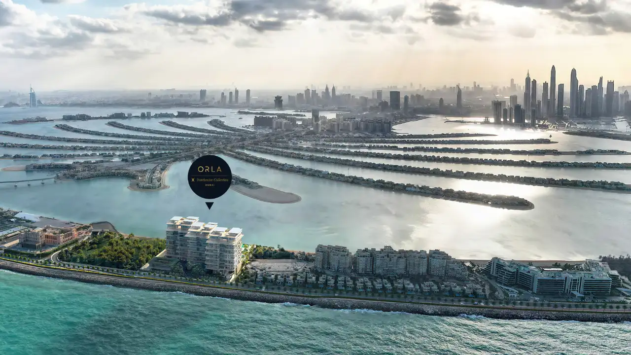 ORLA, Dorchester Collection, Dubai by OMNIYAT location within Palm Jumeirah showcasing its beachfront setting, surrounding fronds, waterfront views, and Dubai skyline backdrop. Presented by Tohid Fetrat