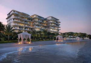 ORLA, Dorchester Collection, Dubai by OMNIYAT private beachfront setting with illuminated residences, landscaped gardens, luxury beach cabanas, and tranquil shoreline views in Dubai. Presented by Tohid Fetrat