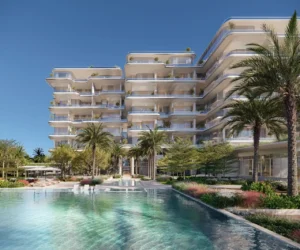 ORLA, Dorchester Collection, Dubai by OMNIYAT resort style swimming pool surrounded by landscaped gardens, palm trees, luxury residences, and outdoor relaxation areas in Dubai. Presented by Tohid Fetrat
