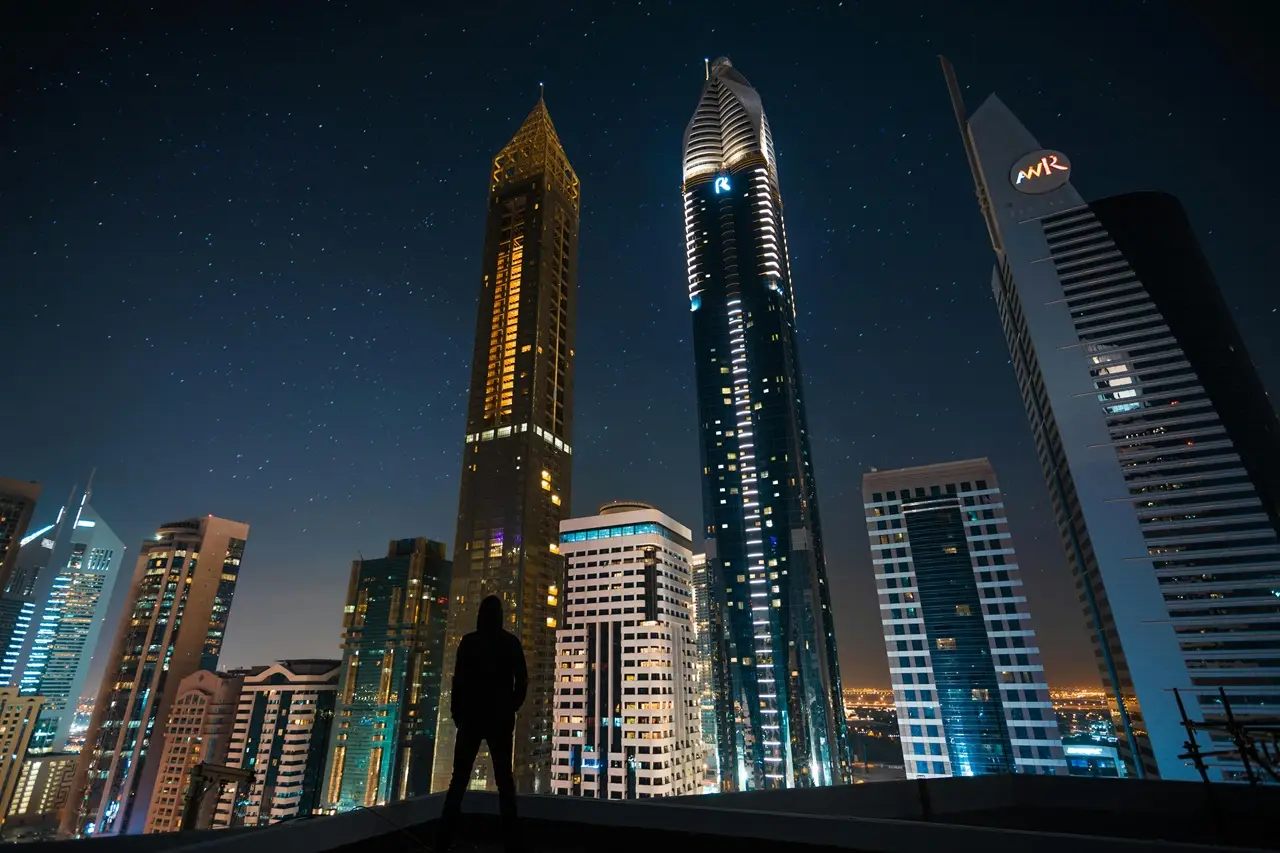 Review Property Type and Unit Selection featuring modern residential towers in Dubai at night representing different property investment options Presented by Tohid Fetrat