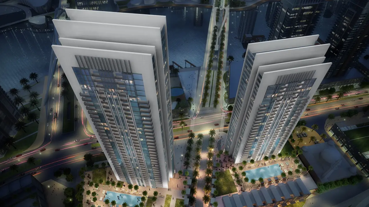 Creek Gate at Dubai Creek Harbour by Emaar Properties aerial night view of twin residential towers with landscaped podium, swimming pools and surrounding waterfront in Dubai - Presented by Tohid Fetrat