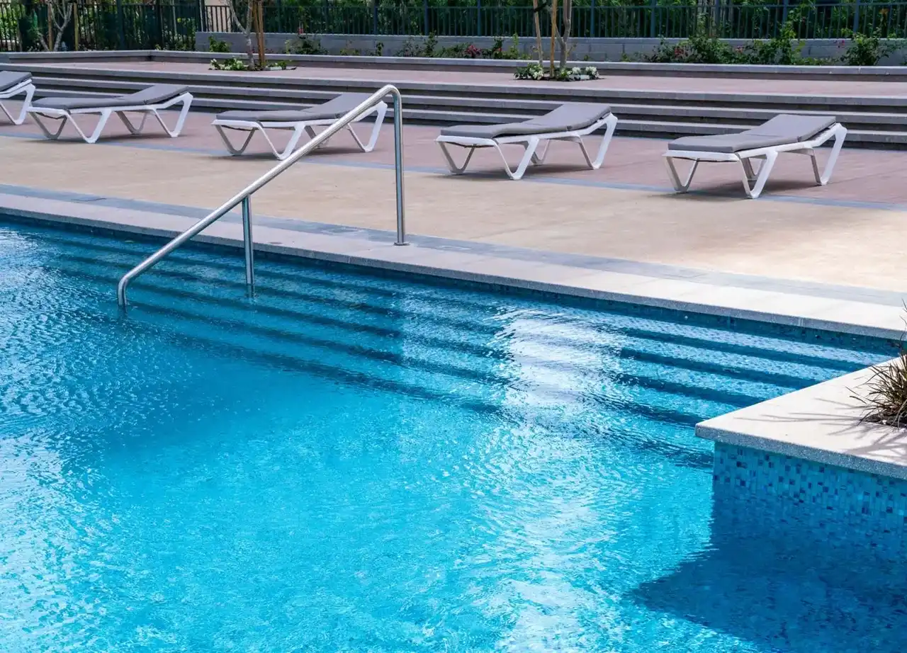Dubai Creek Residences at Dubai Creek Harbour by Emaar Properties outdoor swimming pool with sun loungers and landscaped pool deck in Dubai Presented by Tohid Fetrat
