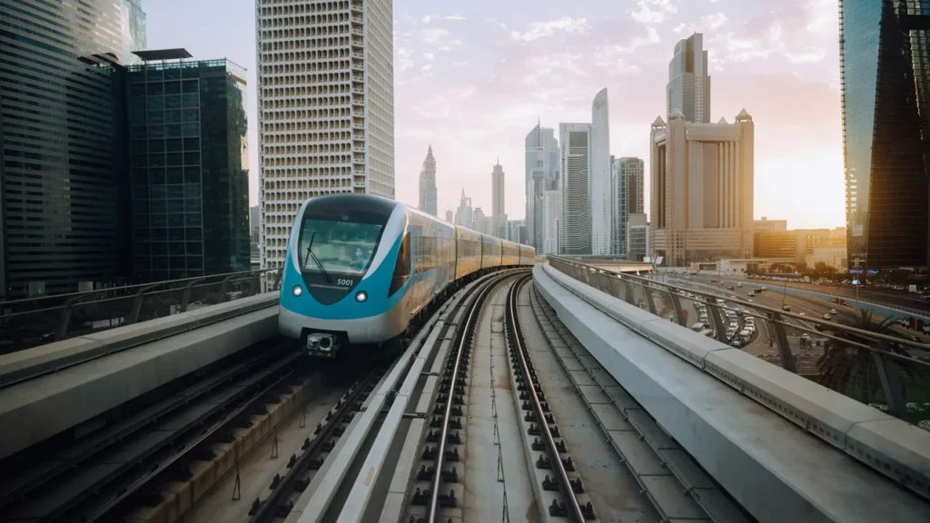 Dubai Metro Gold Line featuring a Dubai Metro train traveling through Downtown Dubai with the city's modern skyline and elevated railway. Presented by Tohid Fetrat