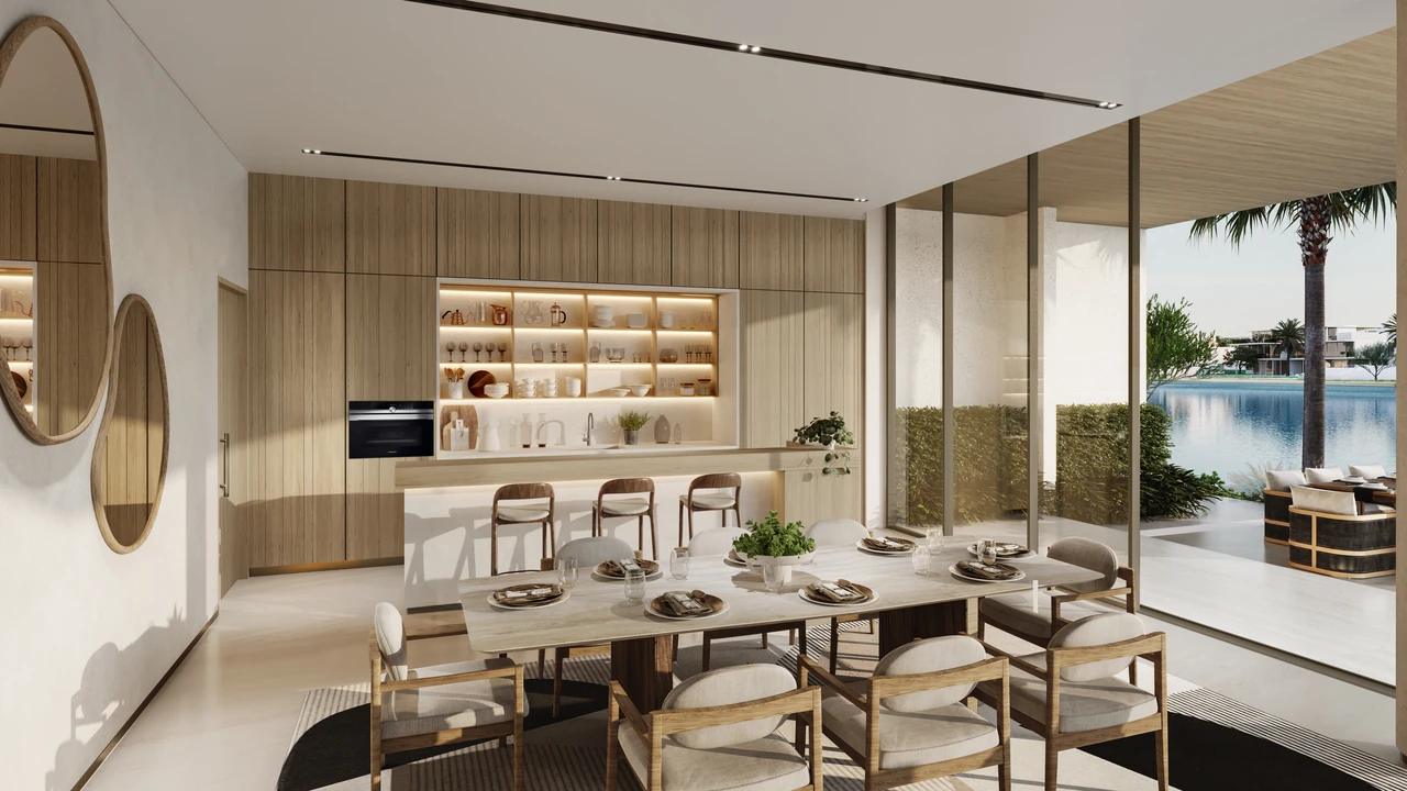 Frond A by Nakheel in Palm Jebel Ali Wave Crest villa dining area and kitchen with timber joinery lit display shelving and pool terrace beyond in Dubai - Presented by Tohid Fetrat