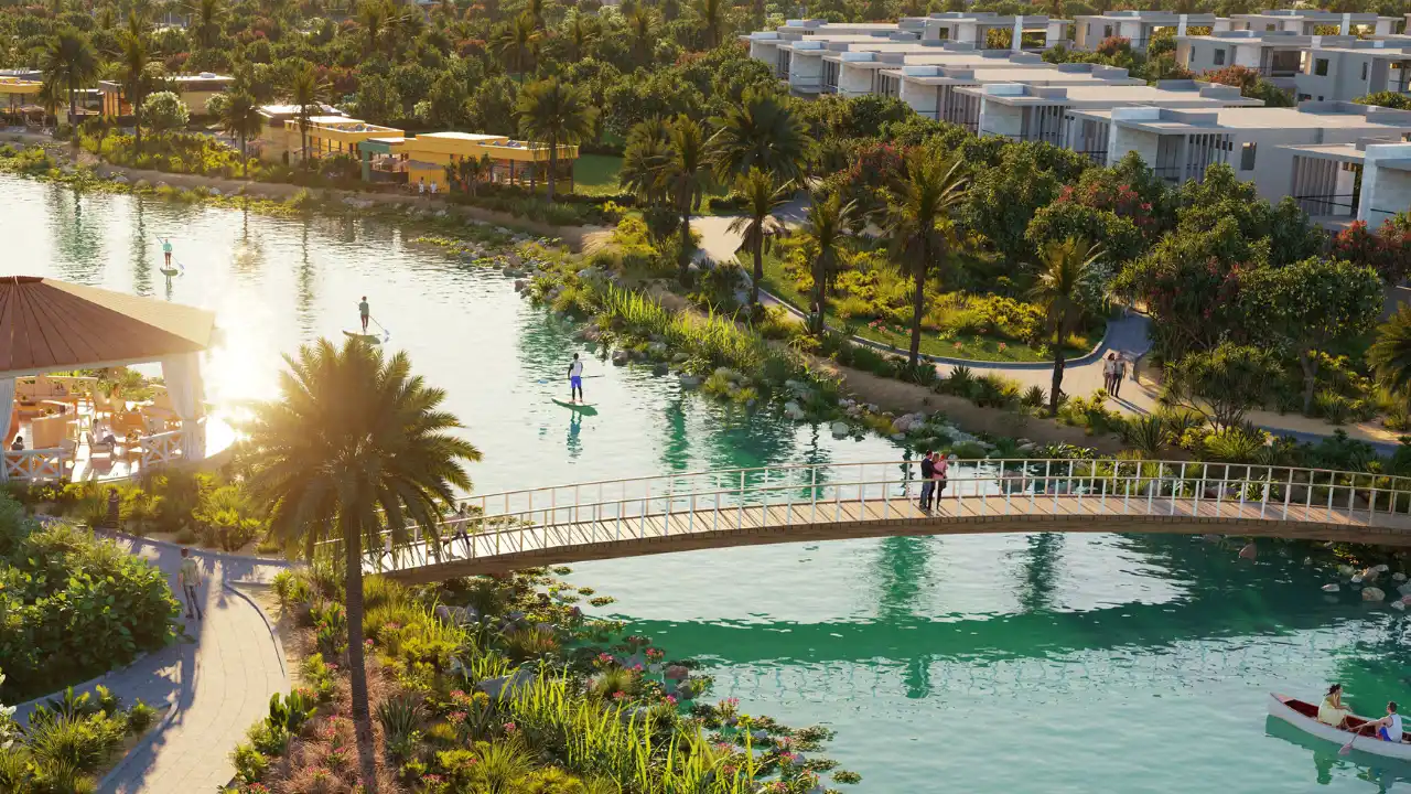 Natura at DAMAC Hills 2 by DAMAC Properties lagoon waterfront with landscaped walking trails pedestrian bridge lush greenery and leisure spaces in Dubai Presented by Tohid Fetrat