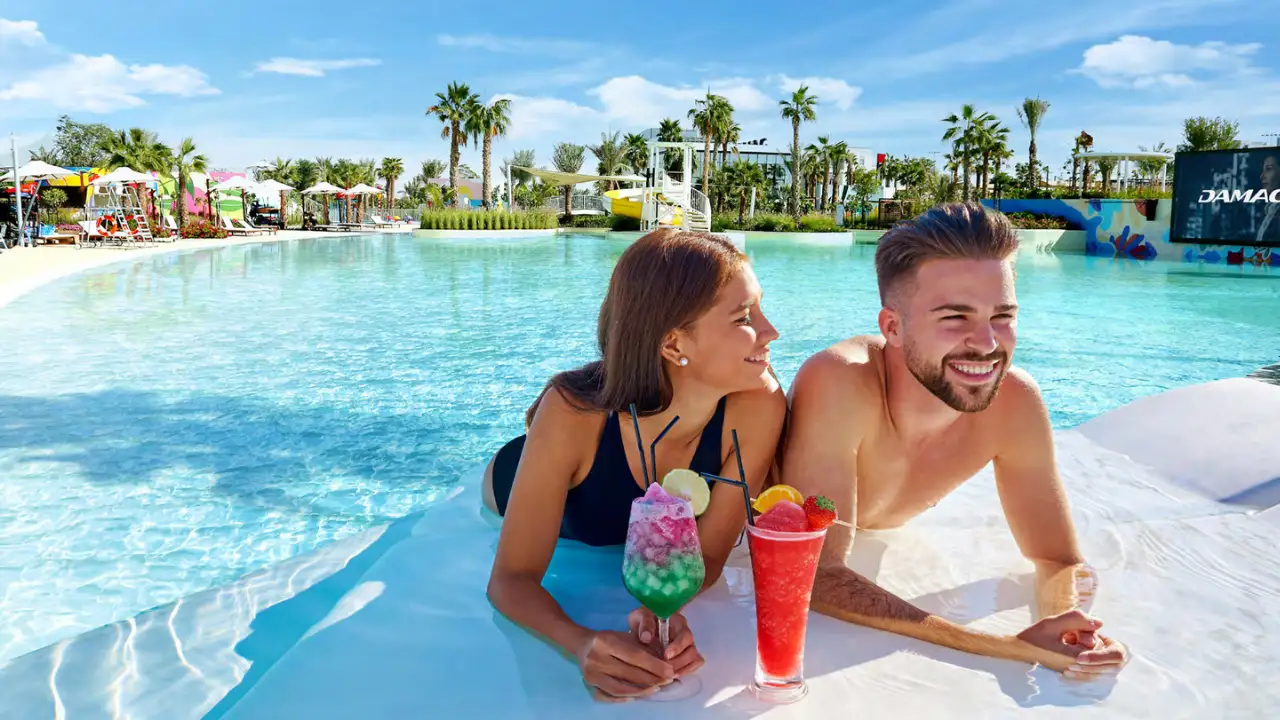 Natura at DAMAC Hills 2 by DAMAC Properties Water Town lagoon pool with resort style leisure area palm trees and relaxing waterside atmosphere in Dubai Presented by Tohid Fetrat