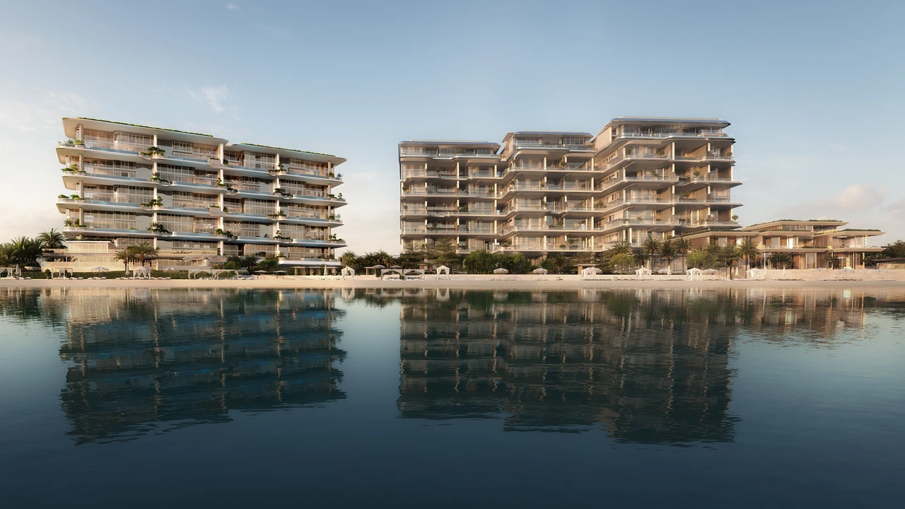 ORLA and ORLA Infinity Dorchester Collection by Omniyat beachfront elevation seen from the sea with layered terraces private beach cabanas and reflective calm water in Dubai - Presented by Tohid Fetrat
