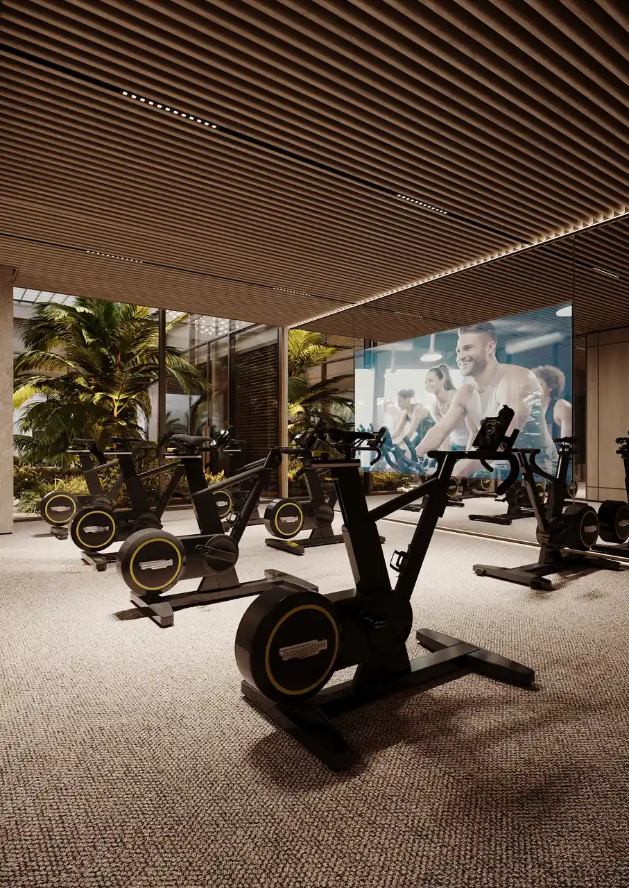 ORLA Infinity Dorchester Collection by Omniyat indoor cycling studio with spin bikes fluted timber ceiling mirrored wall and immersive class screen in Dubai - Presented by Tohid Fetrat