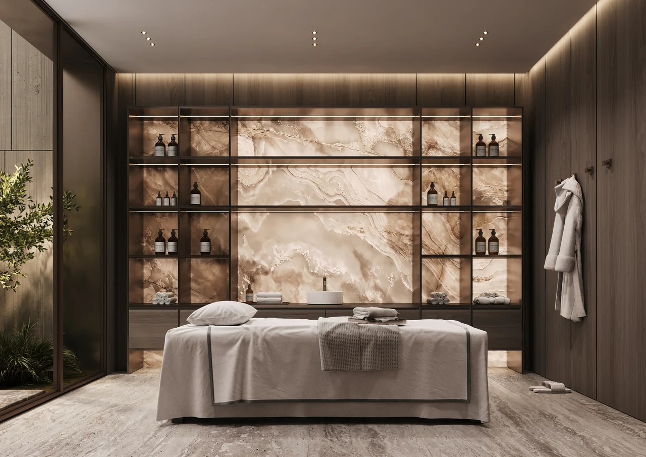 ORLA Infinity Dorchester Collection by Omniyat spa treatment room with massage table backlit onyx wall illuminated product shelving and private planted courtyard in Dubai - Presented by Tohid Fetrat